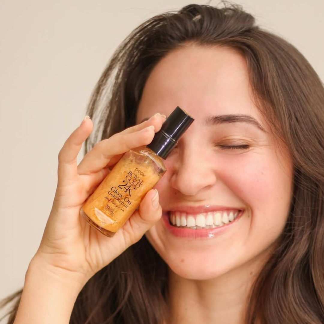 Woman applying a cosmetic product to her face with a neutral background