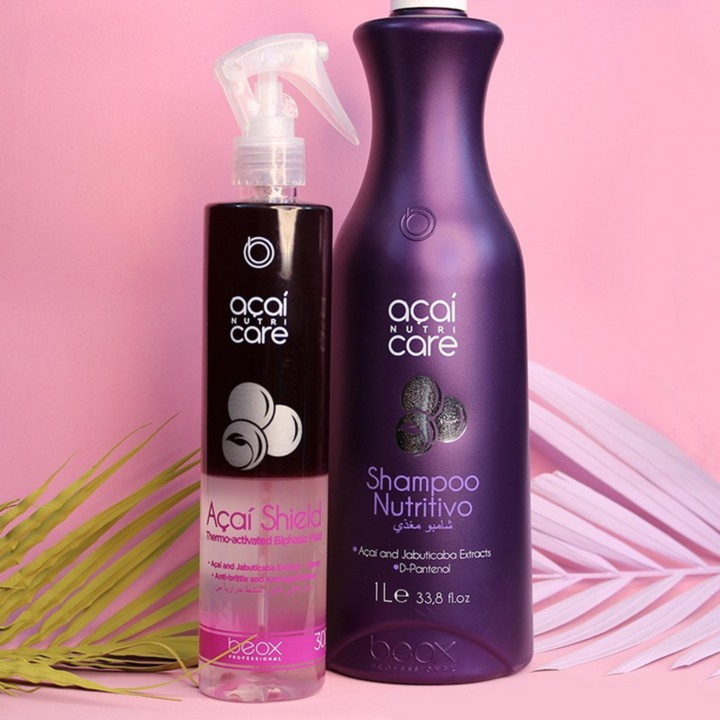 Two acai care hair care products on a pink background with palm leaves.